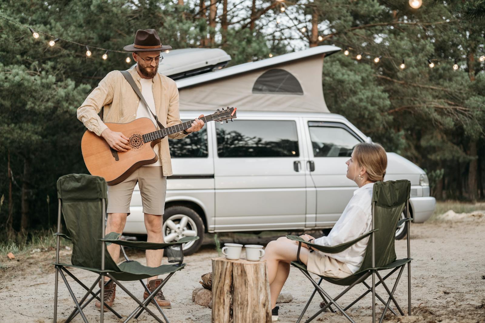 recreational vehicle, couple enjoys a romantic outdoor camping experience with guitar music by their campervan.